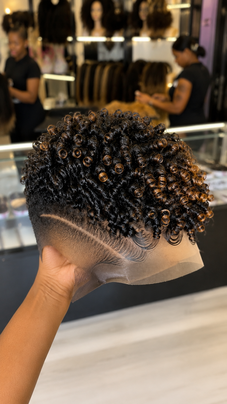 A Solitary Curved Razor Horizon Anchors A Honey-Amber Highlighted Ringlet Pixie Over A Shadow Fade #bwih